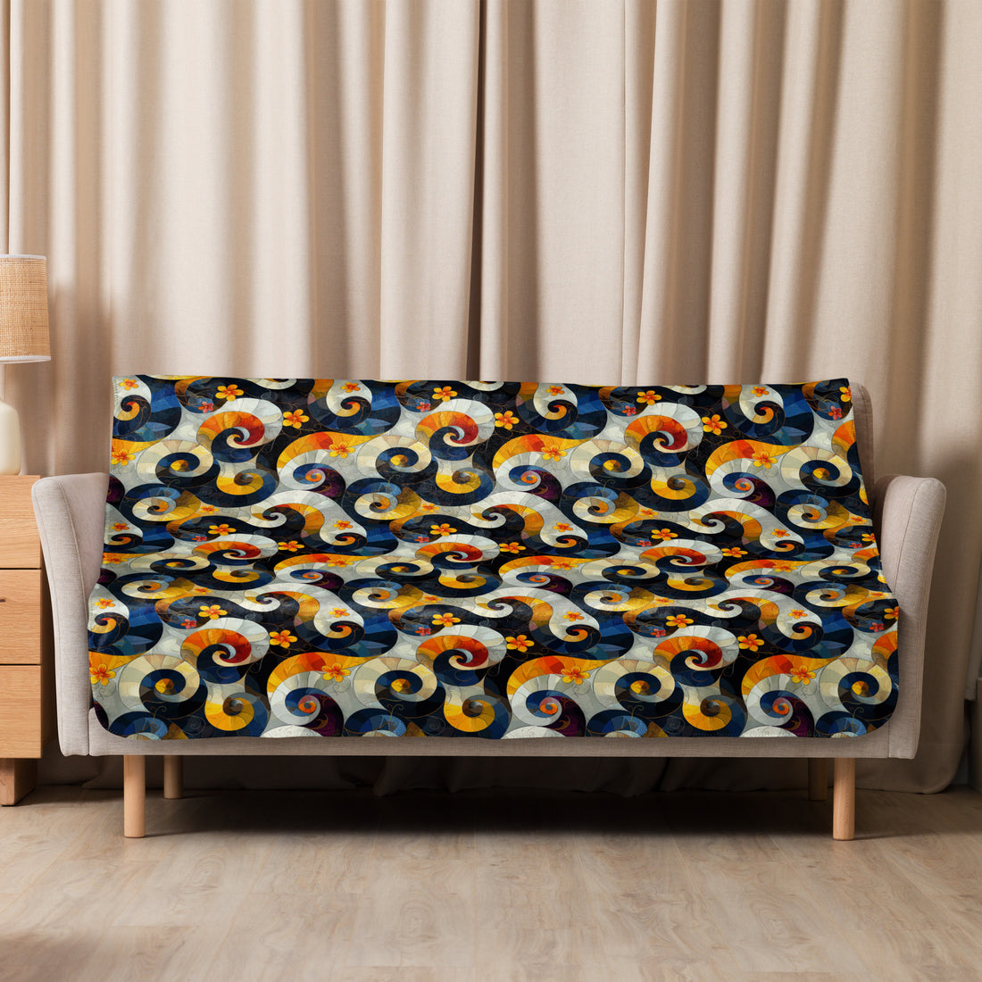 Sherpa blanket with vibrant swirl and floral pattern in navy, mustard, and crimson hues, draped over sofa.