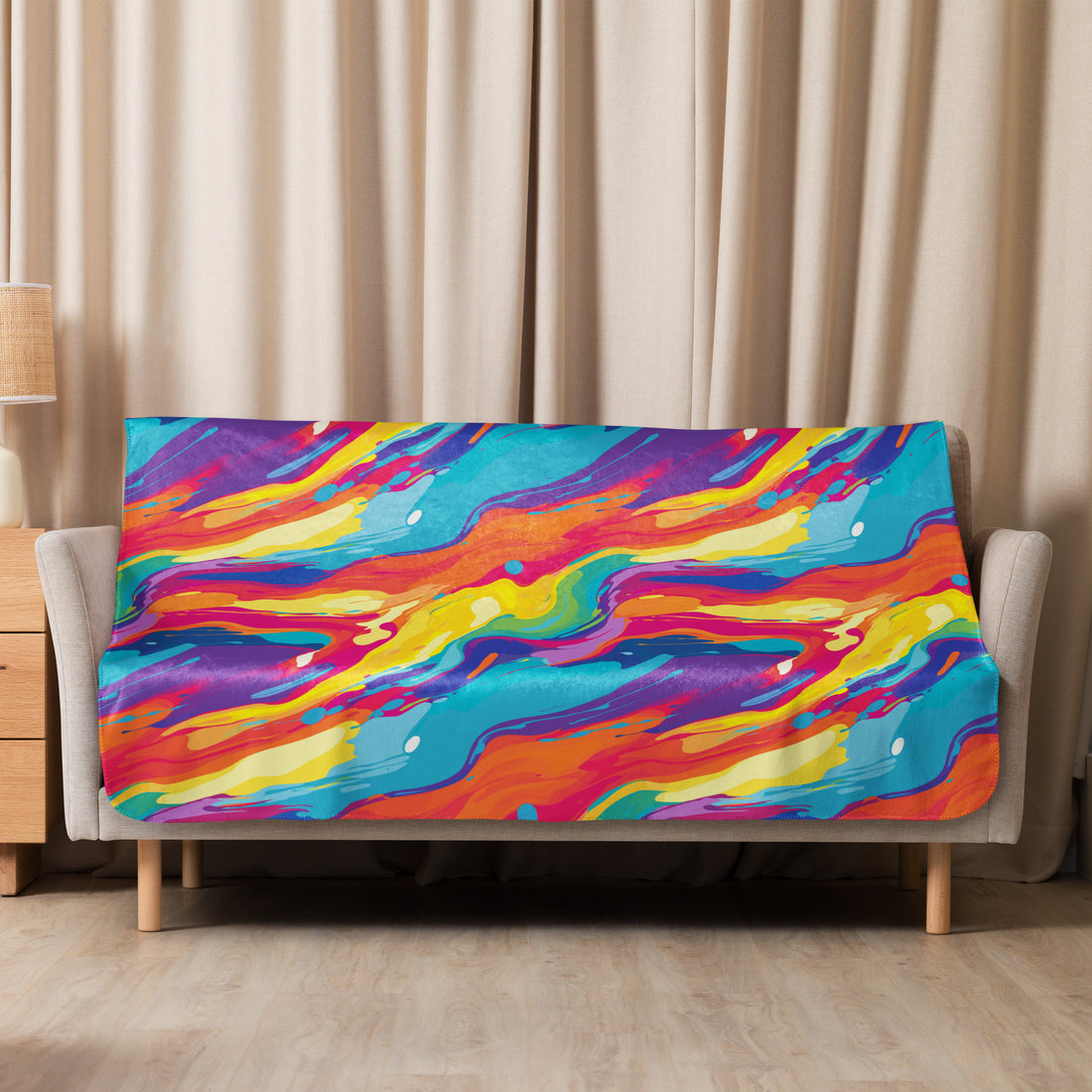 Vibrant abstract Sherpa blanket with swirling blue, red, yellow, and orange design draped over a sofa.