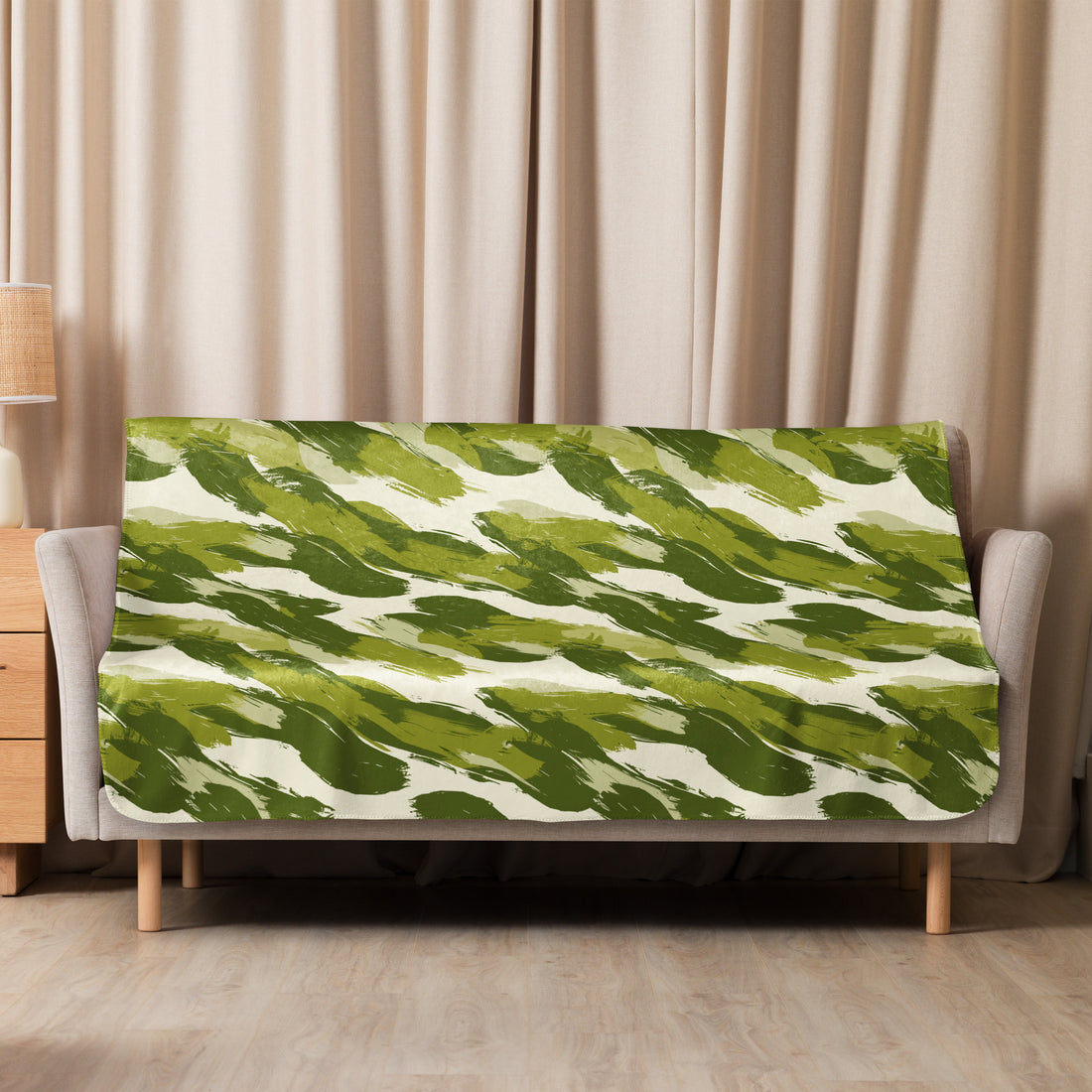 Green camo patterned sherpa blanket draped over a sofa, illustrating its plush texture and vibrant design.