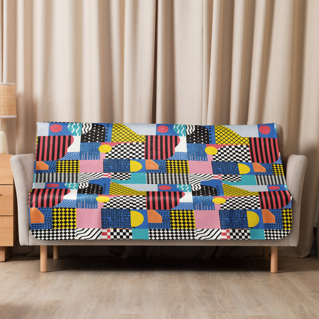 Colorful geometric cozy sherpa blanket in vibrant colors on a sofa.