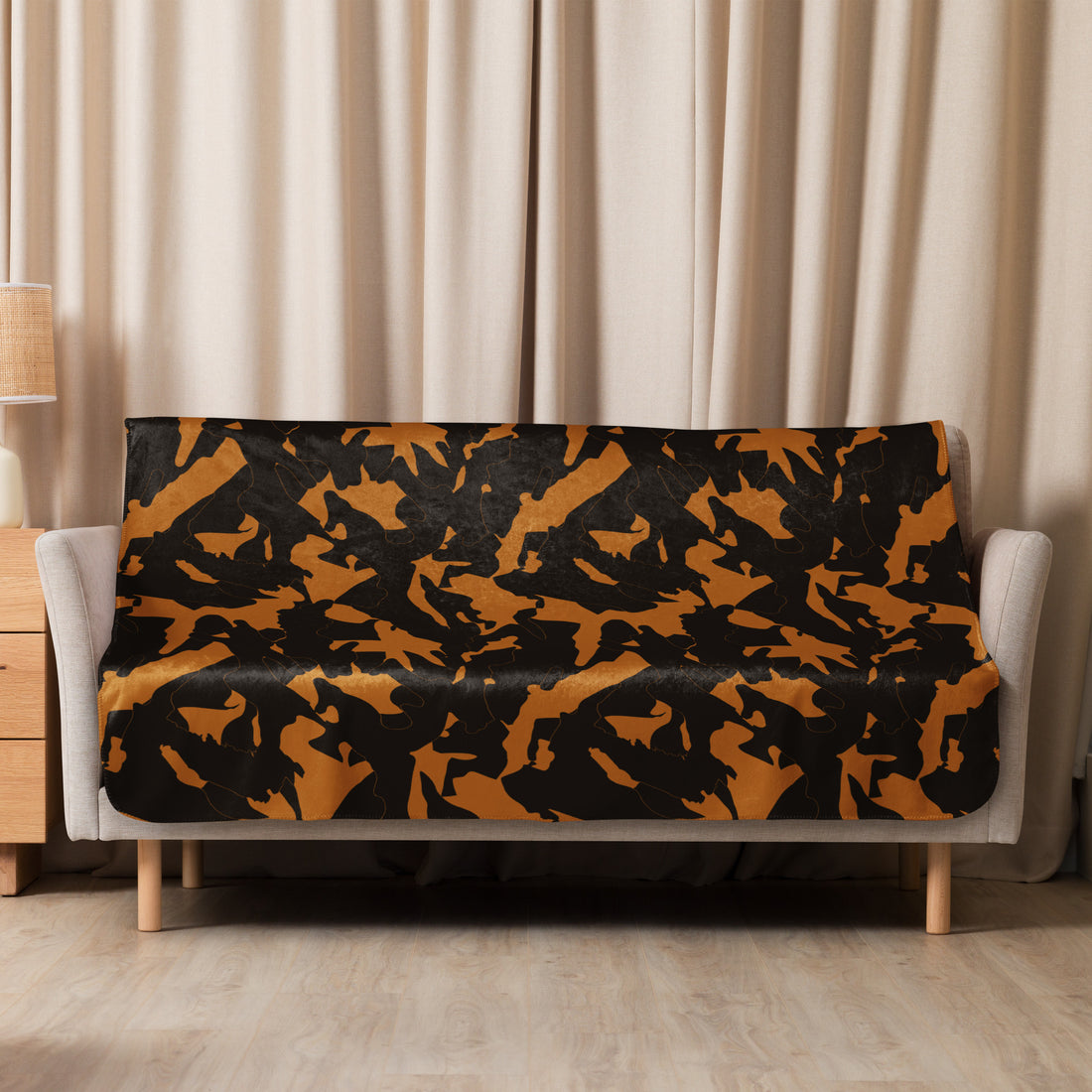 Black and gold camouflage sherpa blanket on a sofa, adding warmth and style to a cozy living room setting.