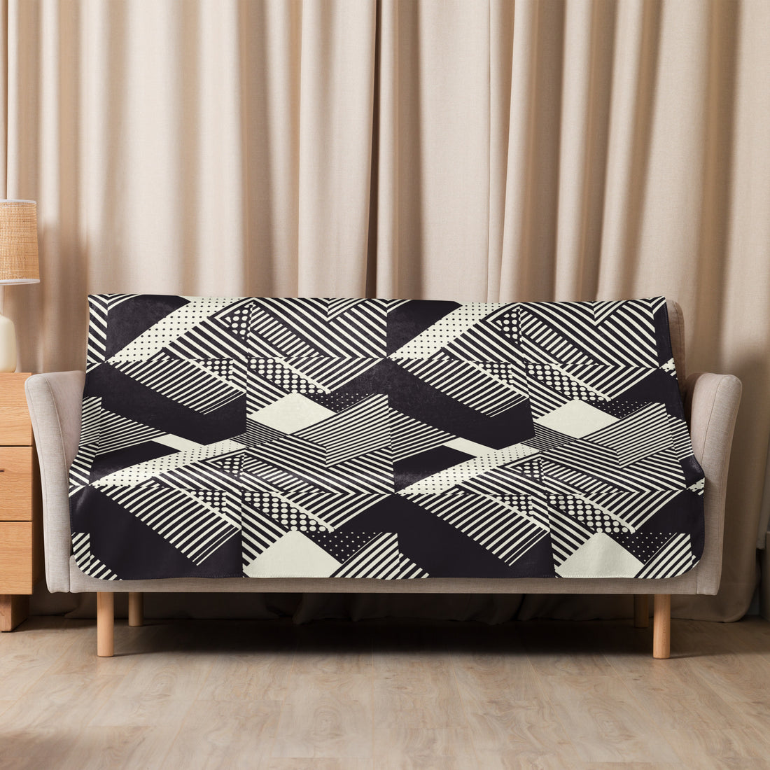 Geometric black and white knitted sherpa blanket draped over a couch