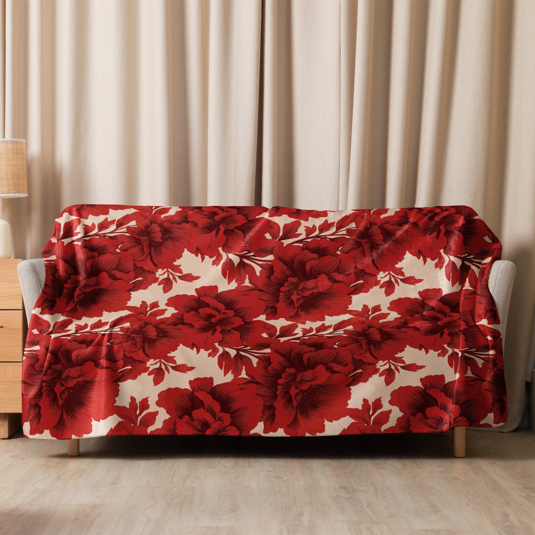 Sherpa blanket draped over a chair, featuring a vibrant scarlet floral pattern on a smooth fabric, suitable for fall and winter decor.