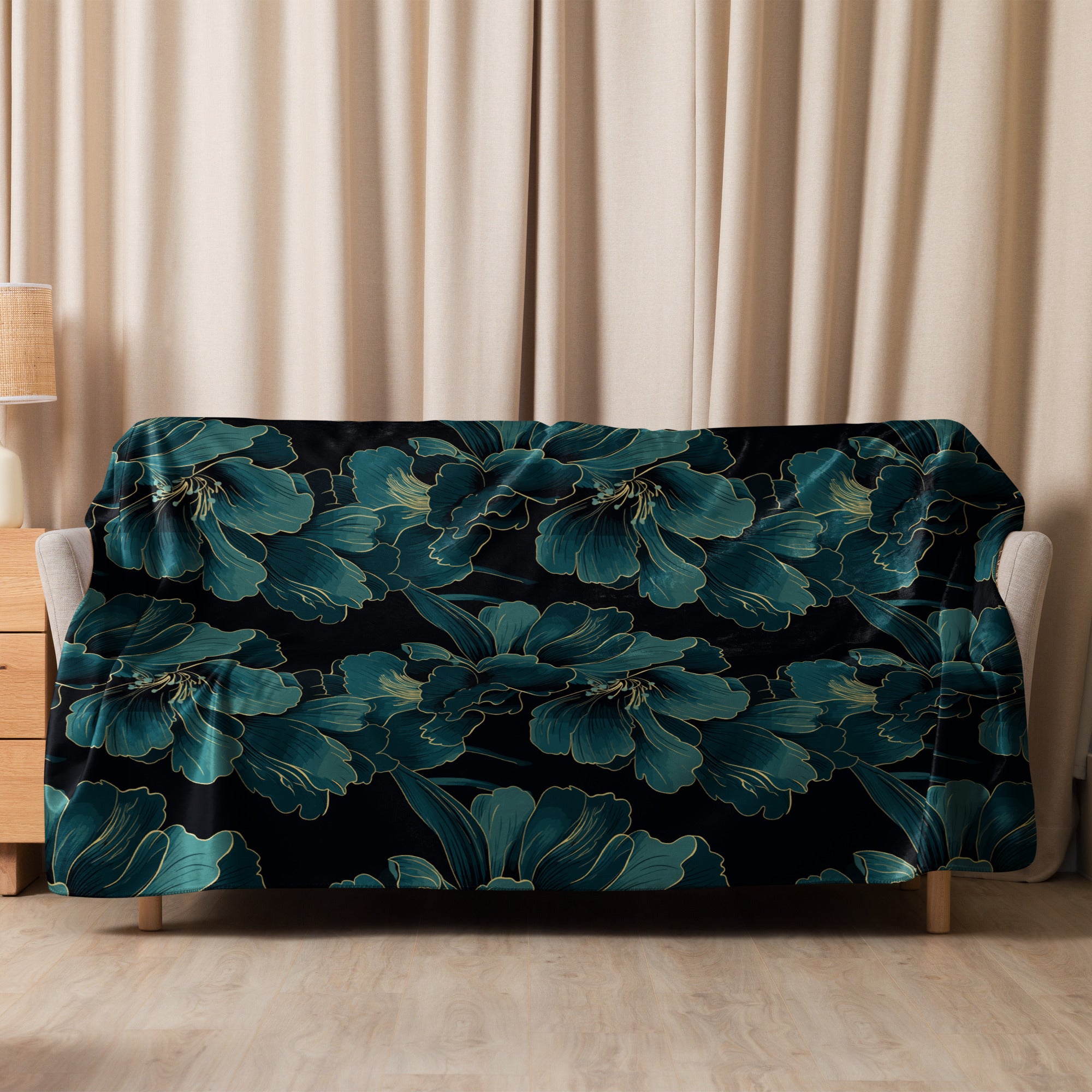 Teal floral sherpa blanket draped over a couch, featuring luxurious botanical patterns in elegant teal and black hues.