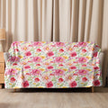 Vibrant pink floral sherpa blanket draped over a couch, showcasing a lush bloom design perfect for cozy holiday warmth.