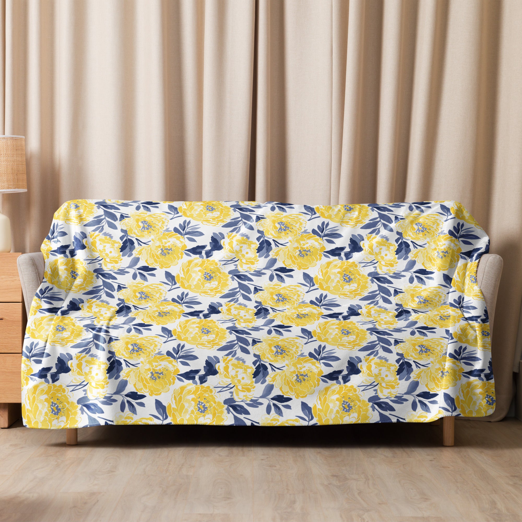 Yellow floral patterned Sherpa blanket draped over a couch, showcasing vibrant yellow flowers against a soft winter-ready design.