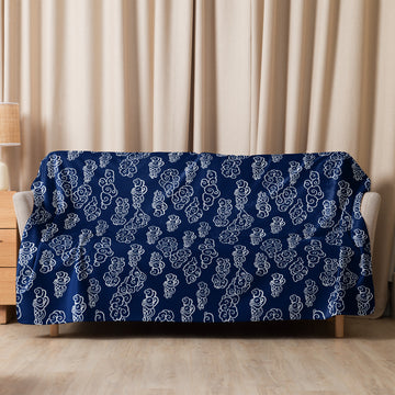 Luxurious navy blue sherpa blanket with whimsical white cloud motif, perfect for cozy winter evenings.