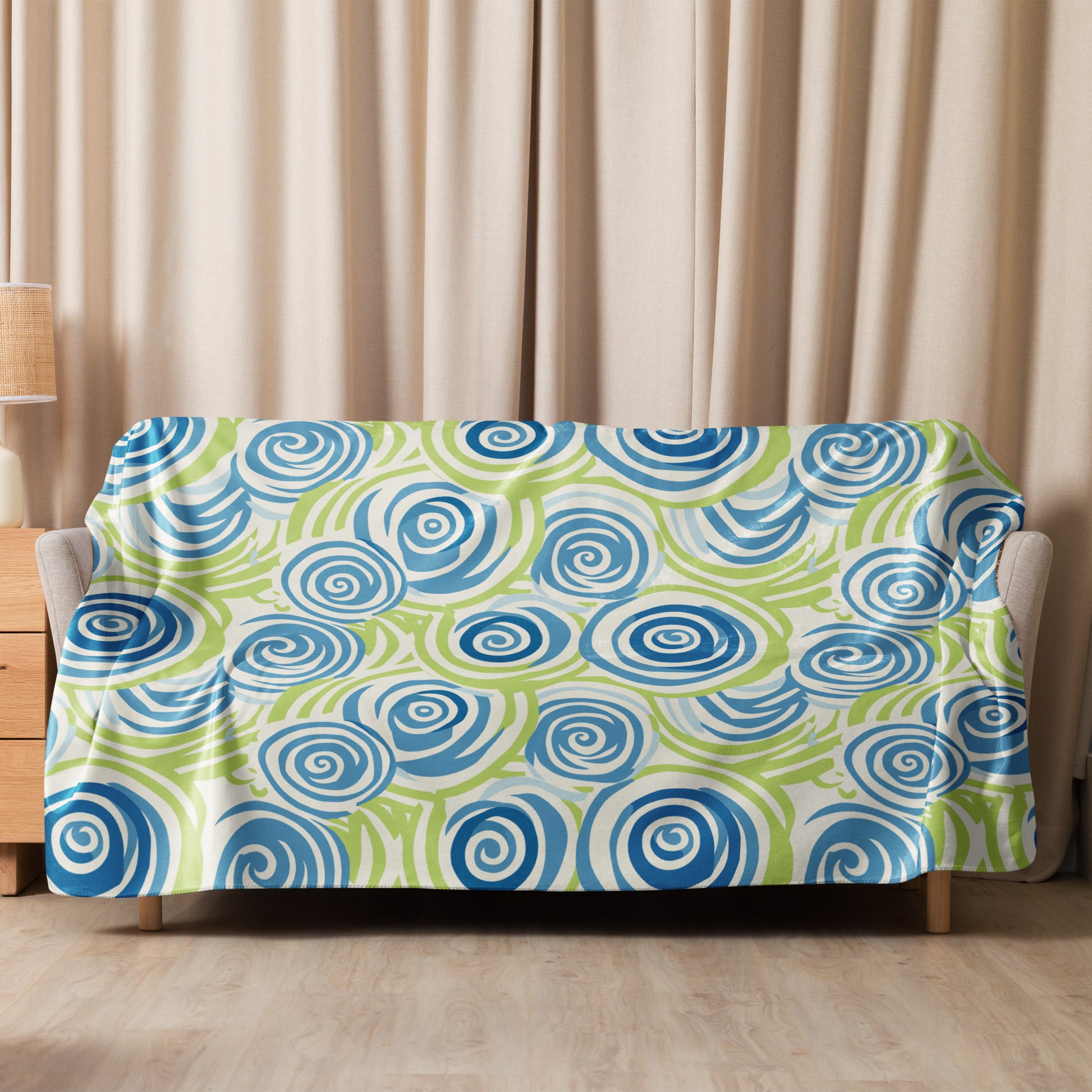 Blue swirl pattern sherpa blanket with vibrant spiral design on soft fabric, draped elegantly over a sofa.