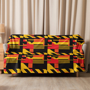 A plush red and yellow geometric patterned sherpa blanket draped over a sofa, with bold and vibrant designs, perfect for cozy winter evenings.