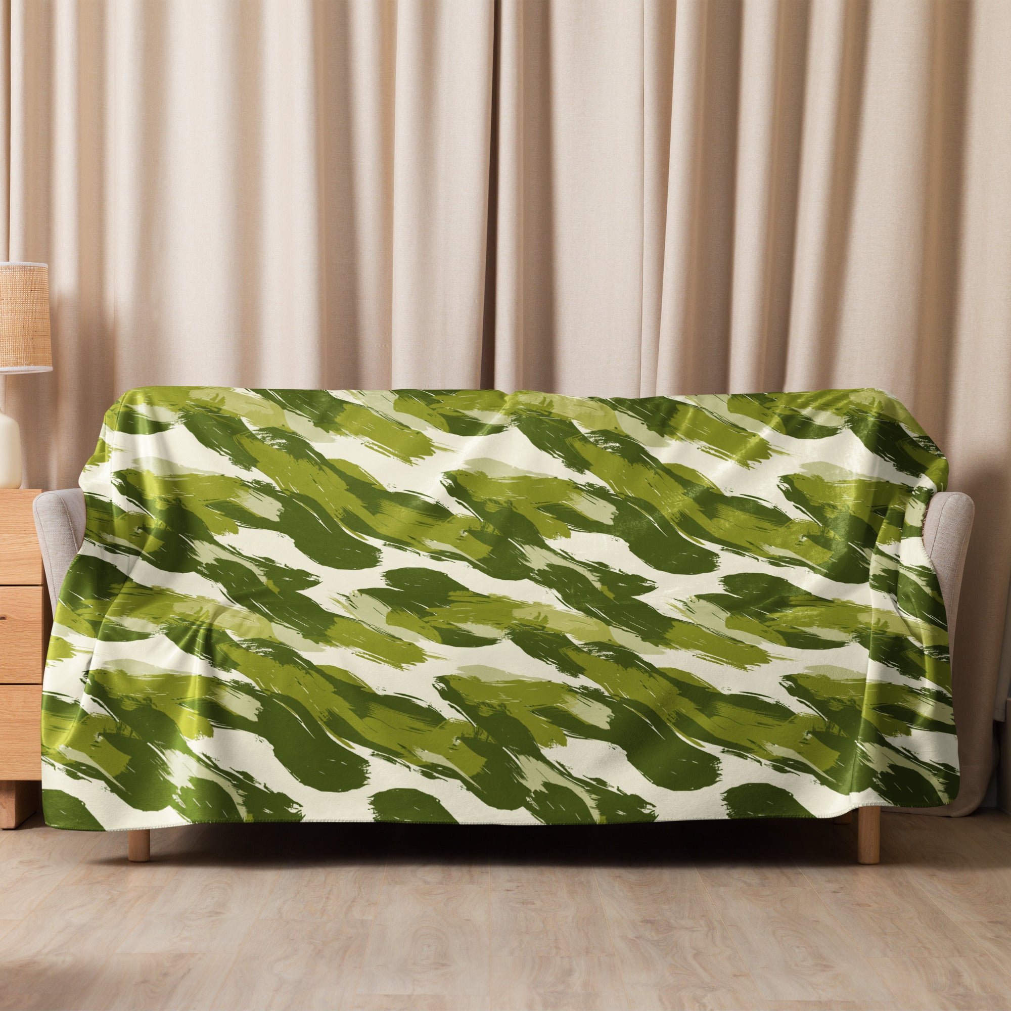 Green camo patterned sherpa blanket draped over a sofa, illustrating its plush texture and vibrant design.