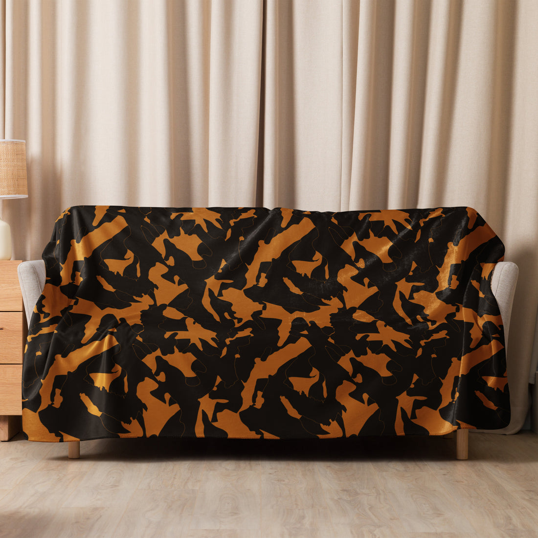 Black and gold camouflage sherpa blanket on a sofa, adding warmth and style to a cozy living room setting.