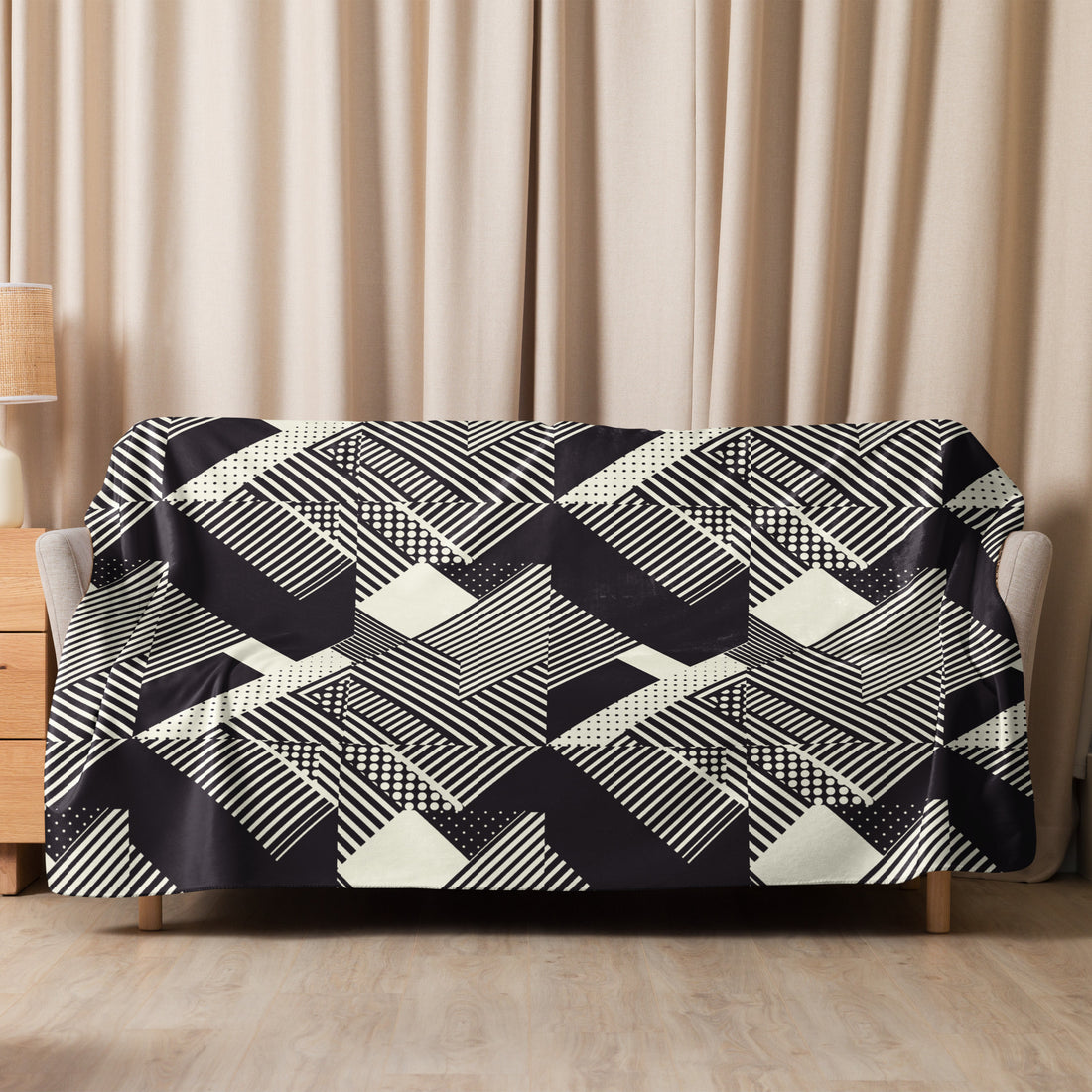 Geometric black and white knitted sherpa blanket draped over a couch