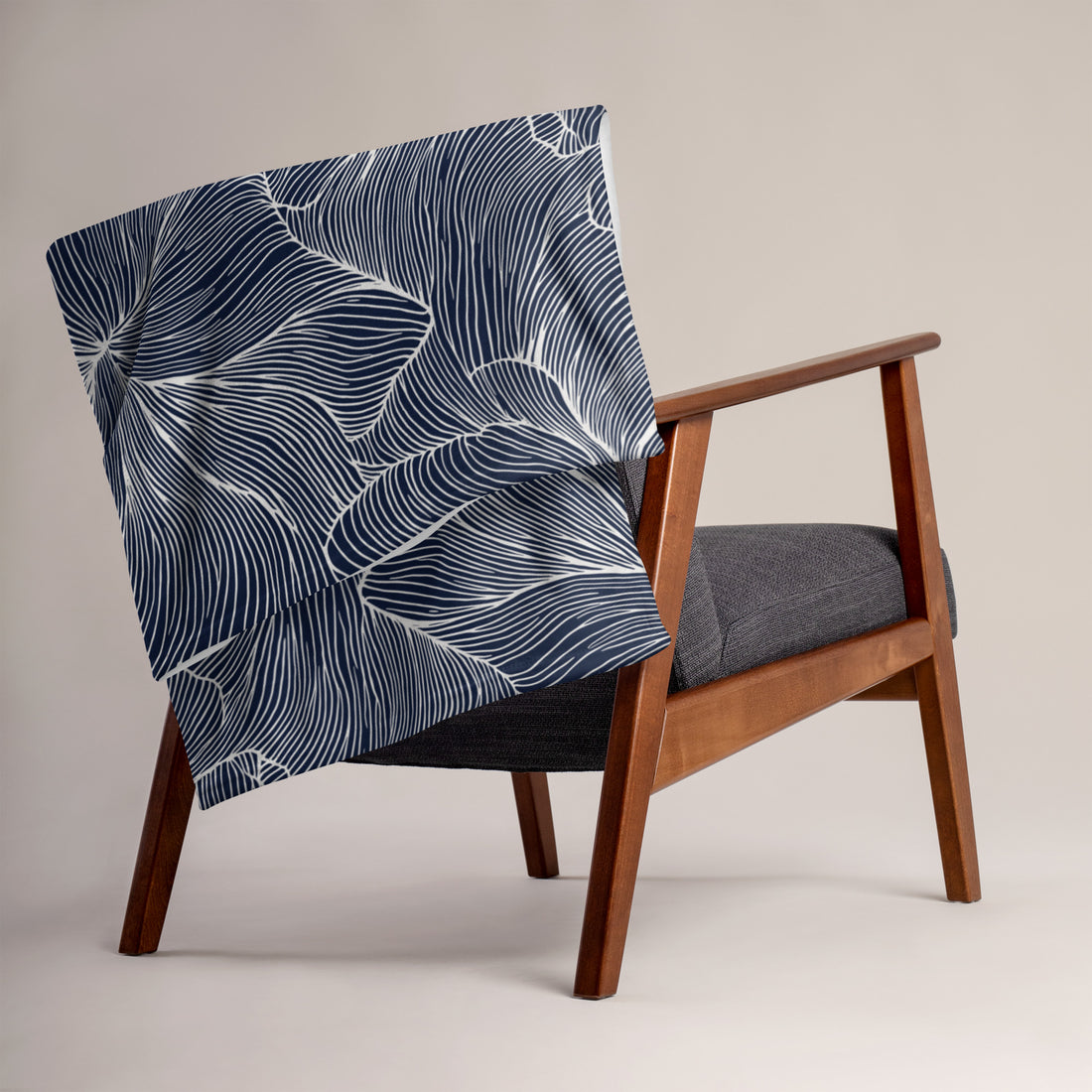 Navy floral silk touch throw blanket draped on a chair, featuring elegant design and soft texture.