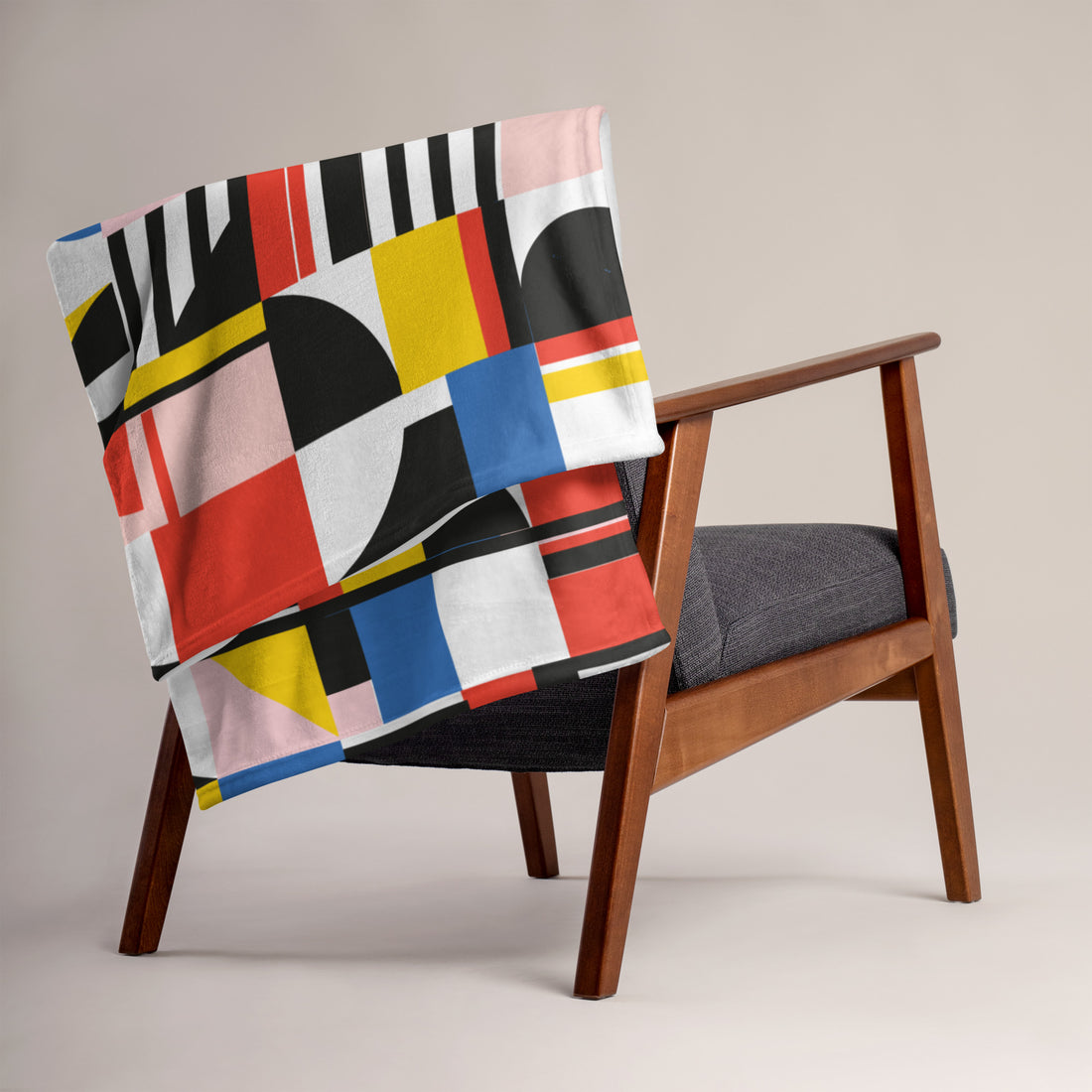 Colorful geometric throw blanket featuring bold patterns on a modern chair.