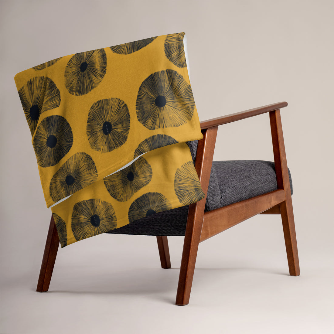 Floral pattern throw blanket in vibrant yellow and black on a chair.