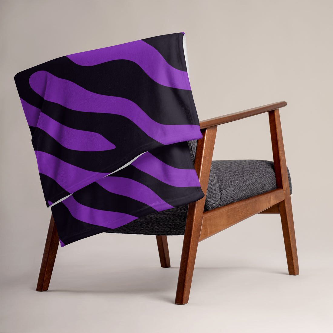 Purple striped throw blanket on a modern chair, showcasing soft silk touch fabric.