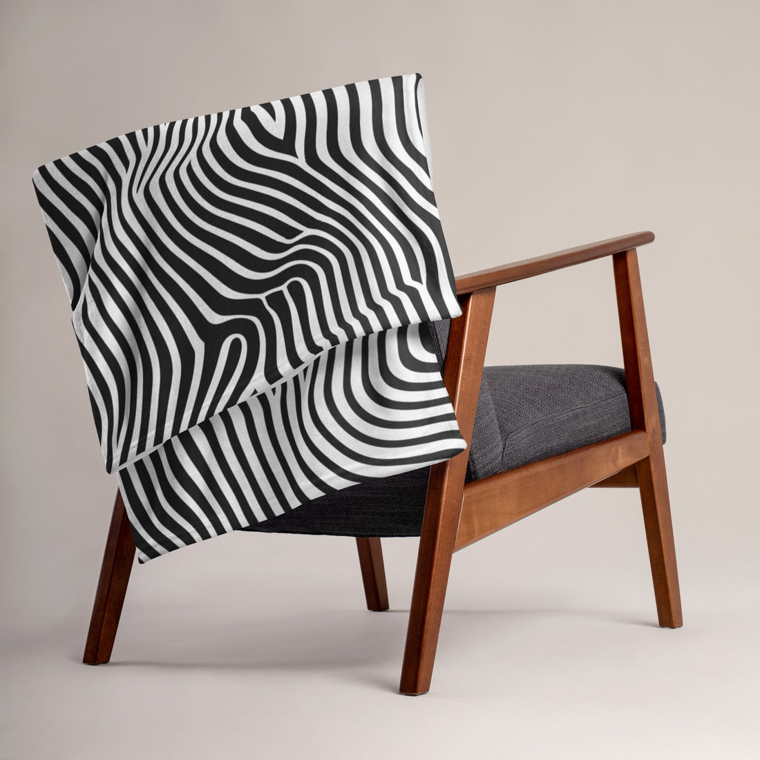 Black and white wavy pattern throw blanket draped over a chair, showcasing its stylish design.