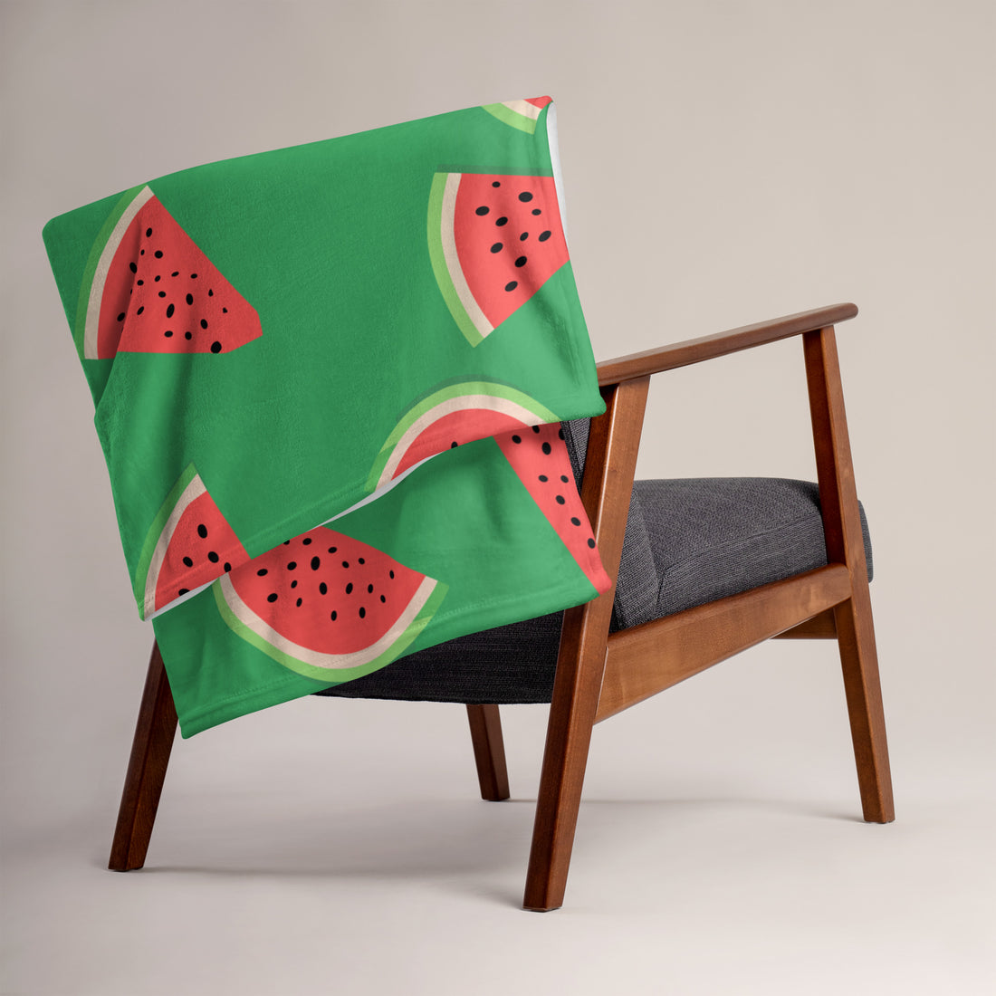 Vibrant watermelon print throw blanket draped over a chair, featuring a bright green background and slices of watermelon.