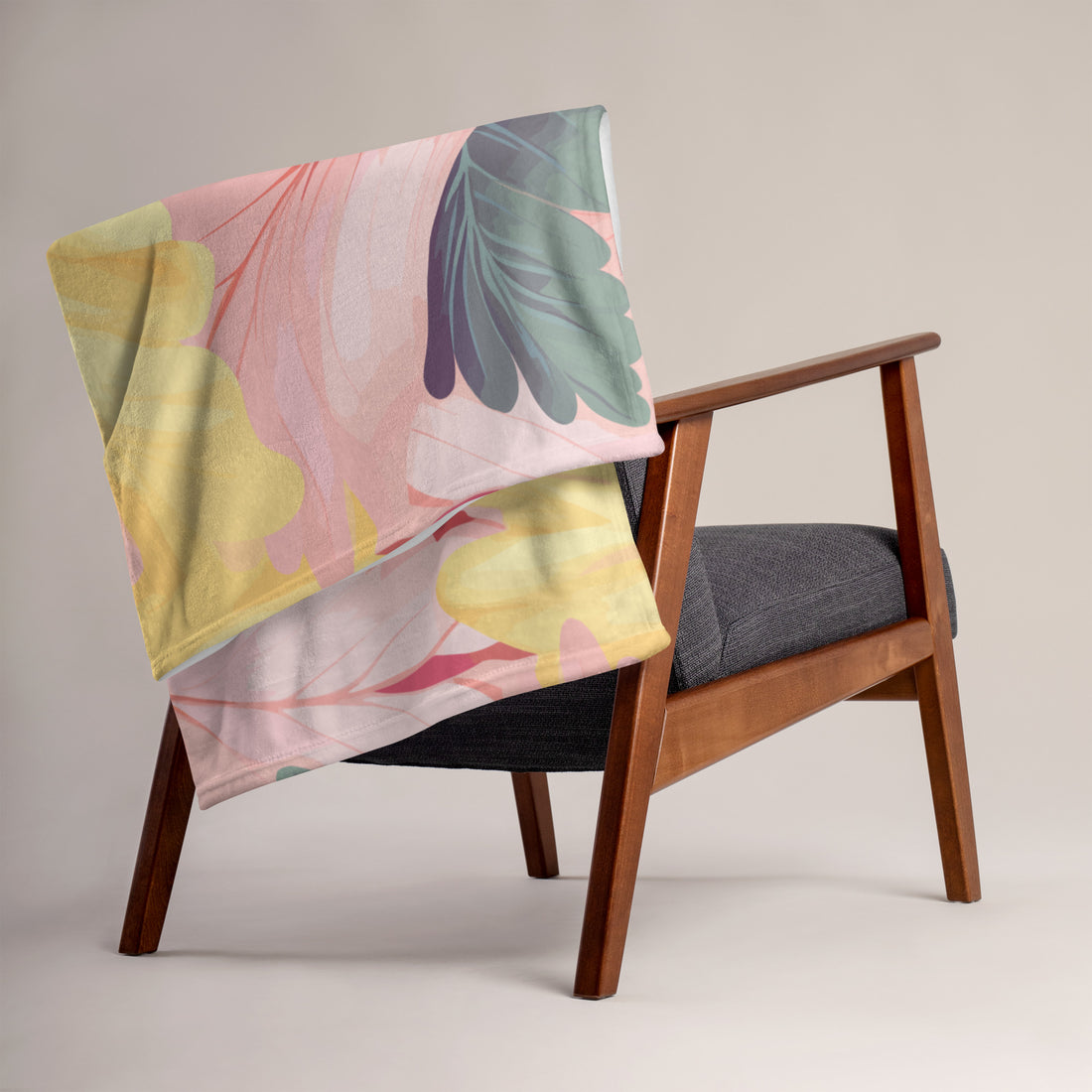 Floral silk touch throw blanket draped over a modern armchair, featuring vibrant yellow and pink floral designs.