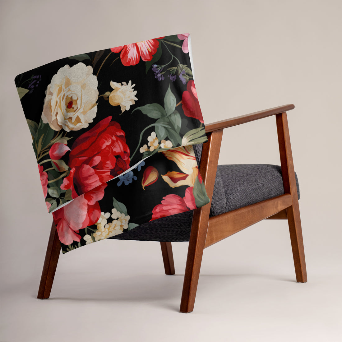 Luxurious floral silk touch throw blanket with vibrant flowers on a black background, draped over an armchair.