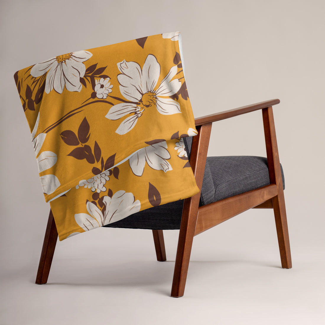 Floral silk touch throw blanket on a chair, featuring a mustard background with white and brown flowers.