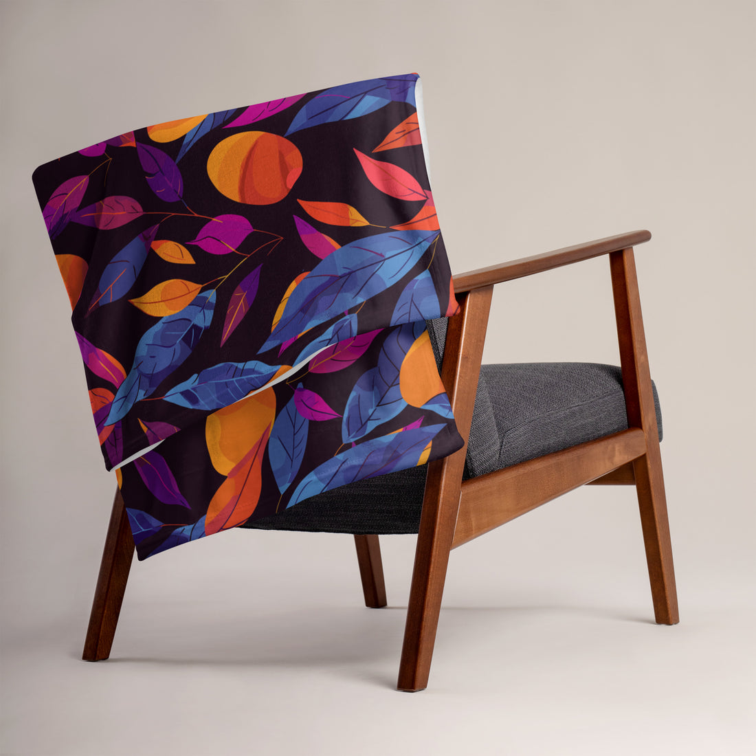 Vibrant autumn leaf silk touch throw blanket in rich orange and navy hues displayed on a chair.