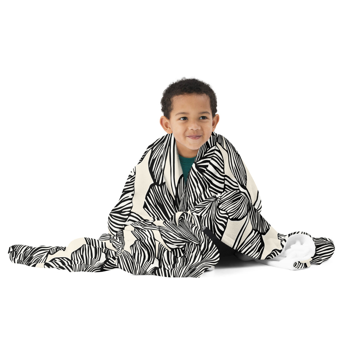 Child wrapped in a zebra stripes black and white knitted throw blanket.