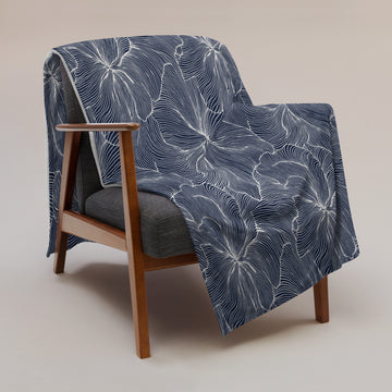 Navy floral silk touch throw blanket draped on a chair, featuring elegant design and soft texture.