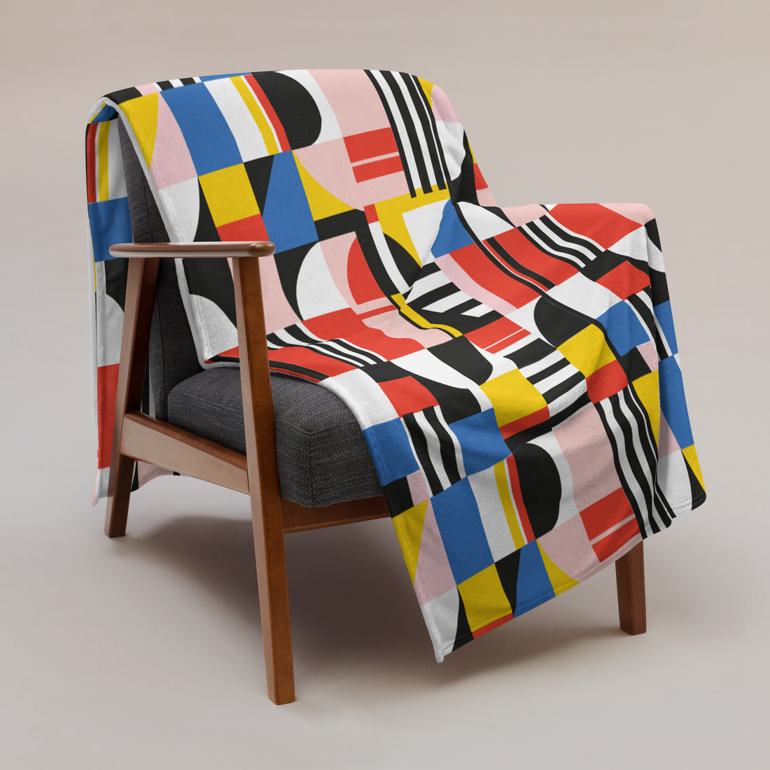 Colorful geometric throw blanket featuring bold patterns on a modern chair.