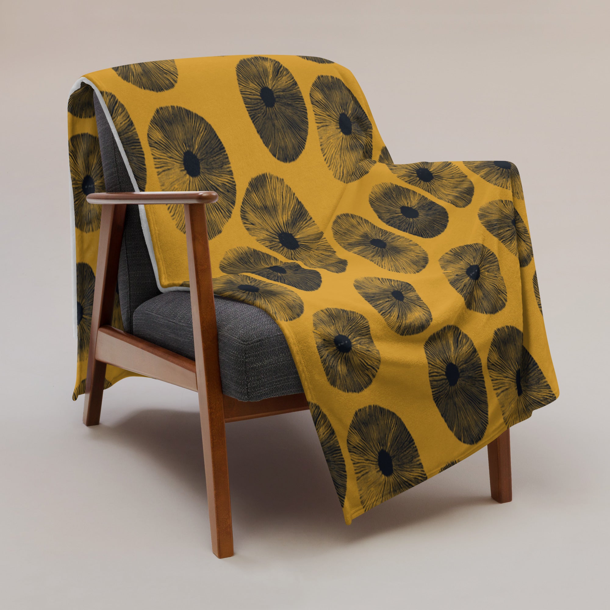 Floral pattern throw blanket in vibrant yellow and black on a chair.