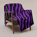 Purple striped throw blanket on a modern chair, showcasing soft silk touch fabric.