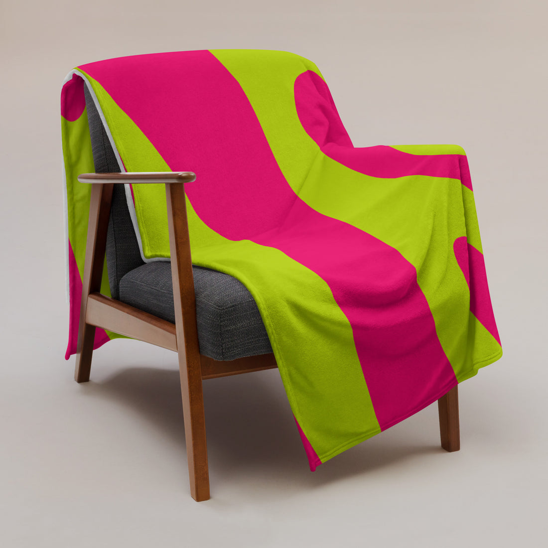 Vibrant pink and green silk touch throw blanket draped over a chair, showcasing bold design.