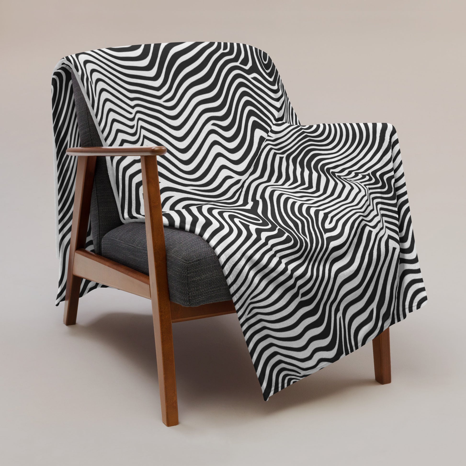 Black and white wavy pattern throw blanket draped over a chair, showcasing its stylish design.