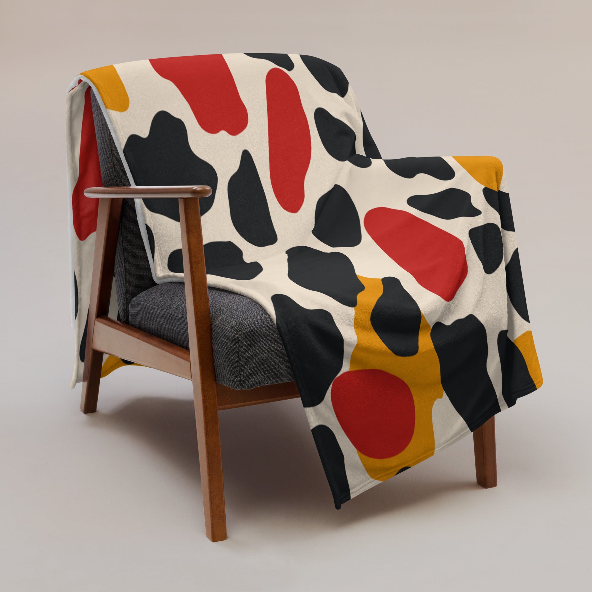 Colorful abstract pattern throw blanket with red, black, and yellow hues.