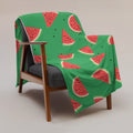 Vibrant watermelon print throw blanket draped over a chair, featuring a bright green background and slices of watermelon.