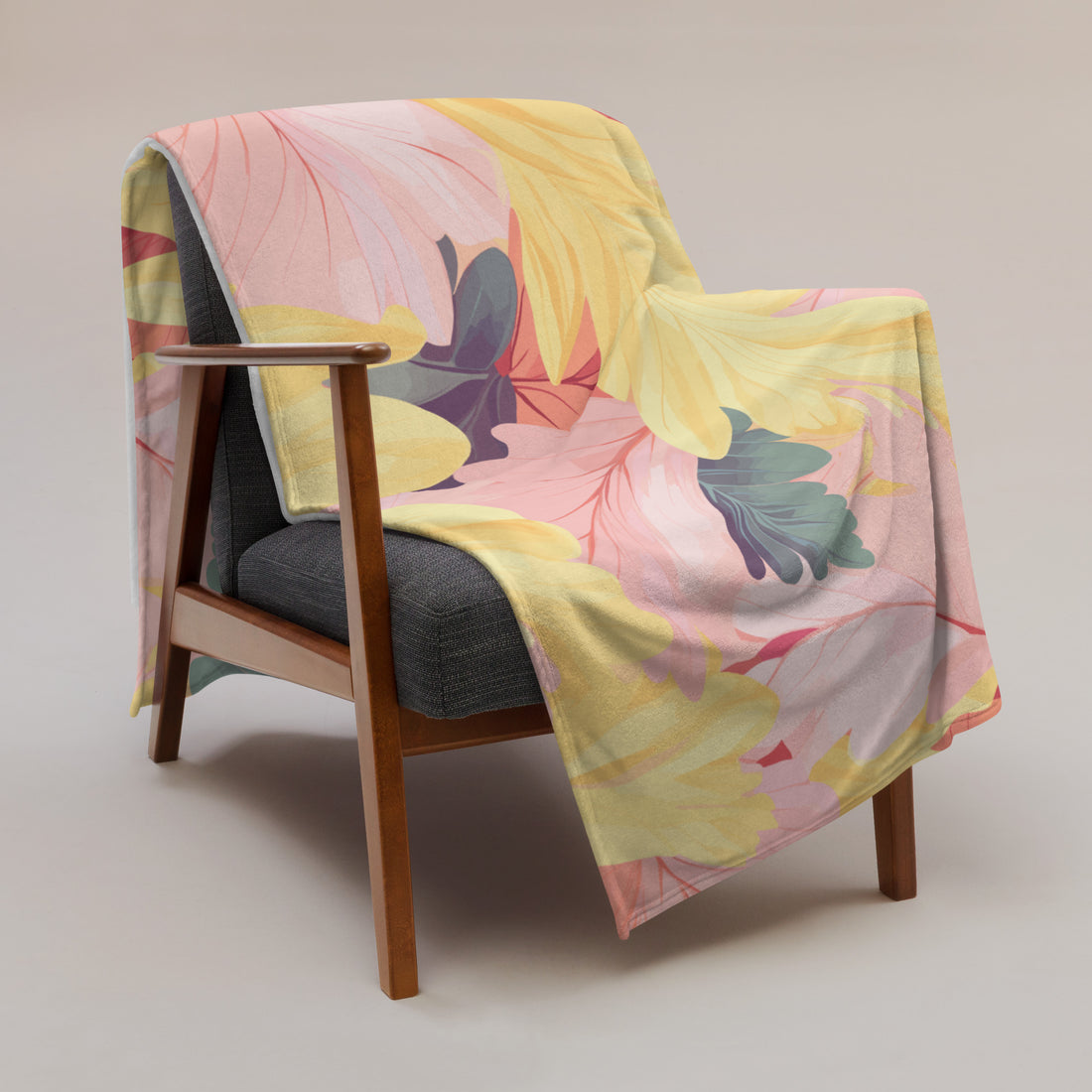 Floral silk touch throw blanket draped over a modern armchair, featuring vibrant yellow and pink floral designs.