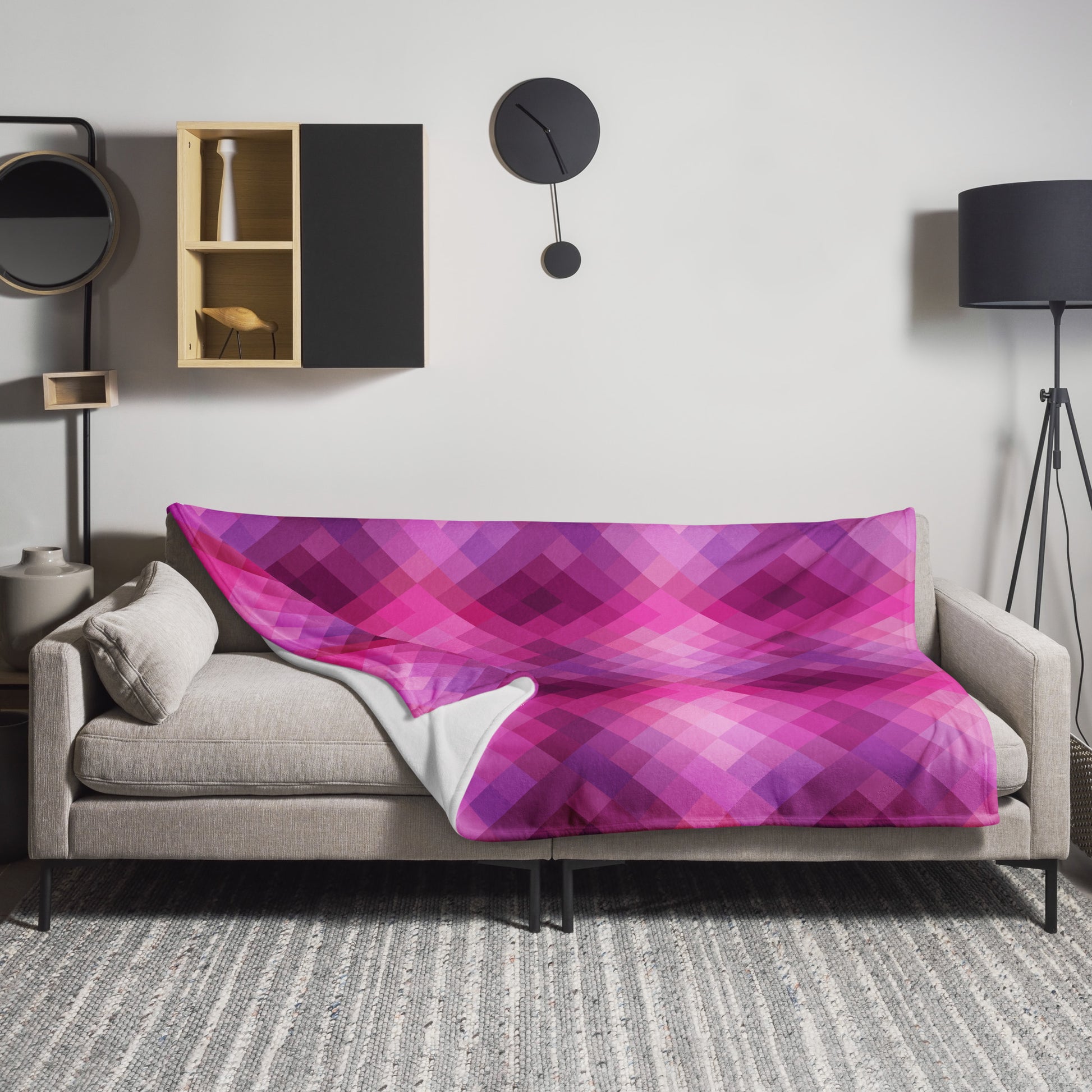 Fuchsia plaid knitted throw blanket draped over a beige sofa in a modern living room setting.