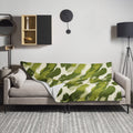 Green Brushstroke Throw Blanket on a sofa, featuring a bold artistic pattern in green and cream hues, enhancing cozy winter decor.