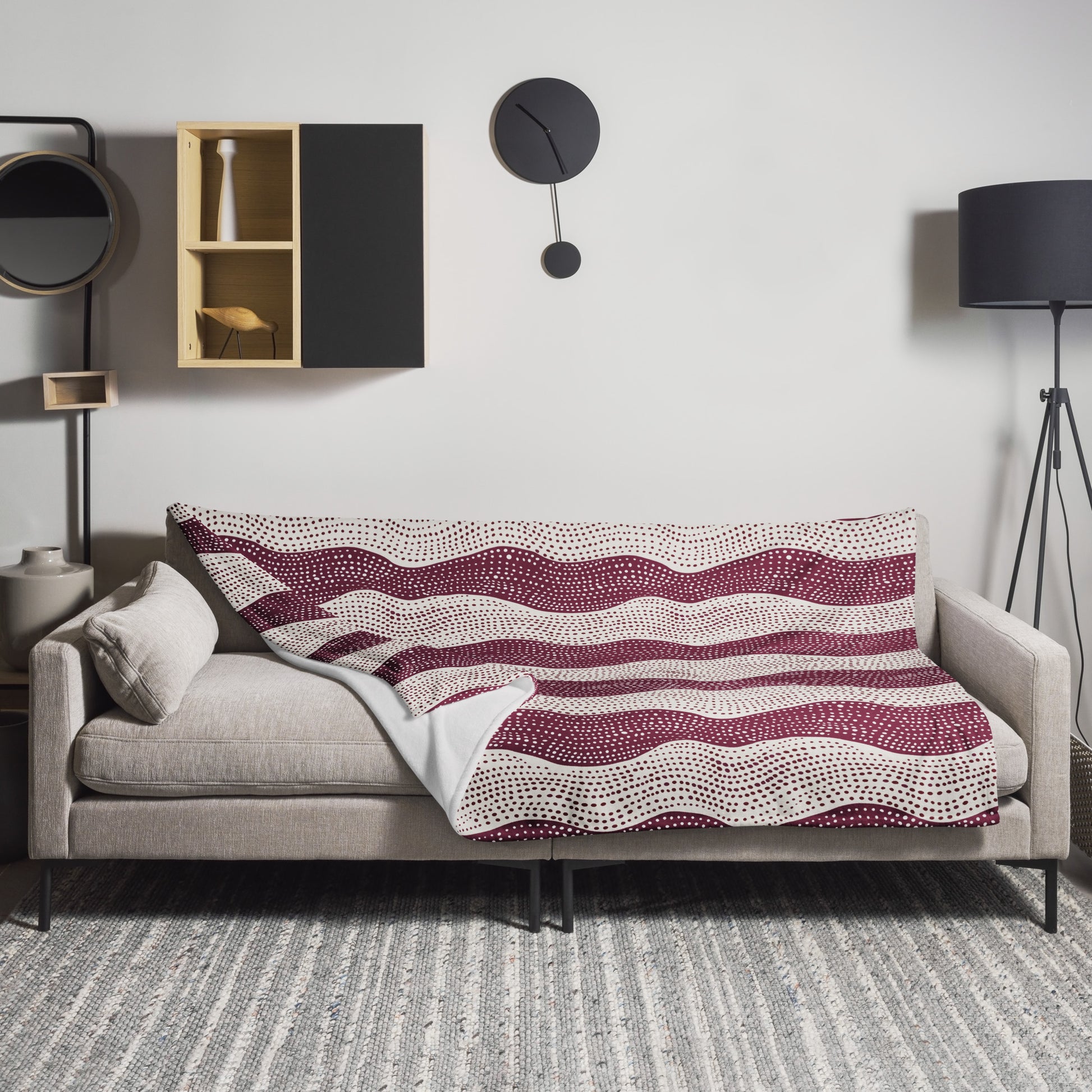 Wave-pattern throw blanket in burgundy and cream, draped over a sofa, showcasing an elegant dotted design.