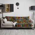 Vibrant African-inspired knitted throw blanket with geometric patterns in rich colors on a couch.