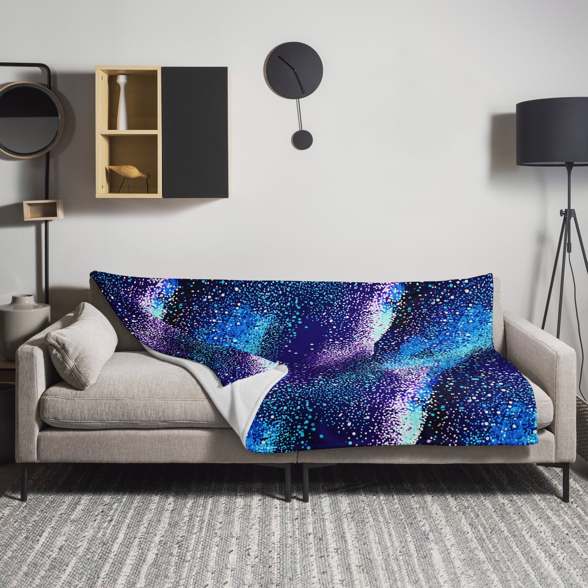 Winter Galaxy Knitted Throw Blanket in deep blues and purples with cosmic design on a sofa