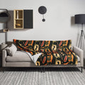 Silk touch throw blanket featuring vibrant ethnic pattern with rich colors on a sofa.