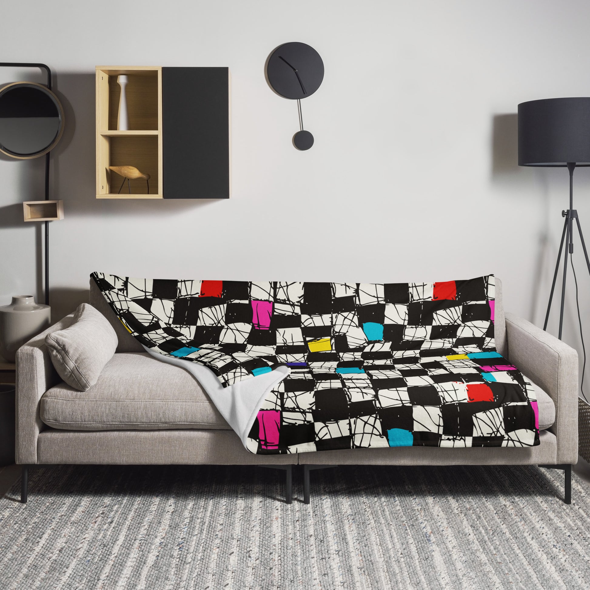 Throw blanket with bold geometric color blocks in various vibrant colors on a couch.